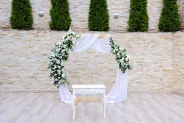 Beyaz ve yeşil güllerle süslenmiş düğün kemeri. Eski tarz. Seçici odak.