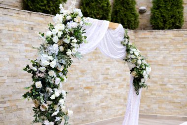 Beyaz ve yeşil güllerle süslenmiş düğün kemeri. Eski tarz. Seçici odak.