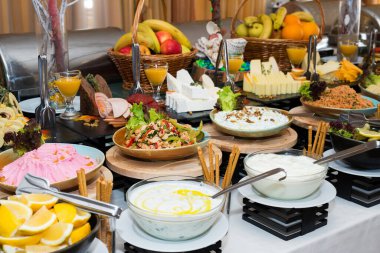 Tatil için atıştırmalıklar, yemek servisi. Çeşitli atıştırmalıklar. Salata çeşitleri ve açık büfe yemekleri. Etler, balıklar, peynir, salatalar, meyve ve sebzeler, soslar ve kanepeler bayram etkinliğini kutlamak için..