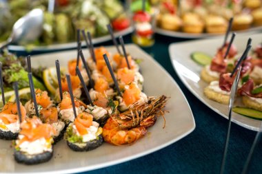 Tatil için atıştırmalıklar, yemek servisi. Çeşitli atıştırmalıklar. Salata çeşitleri ve açık büfe yemekleri. Etler, balıklar, peynir, salatalar, meyve ve sebzeler, soslar ve kanepeler bayram etkinliğini kutlamak için..