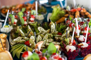 Tatil için atıştırmalıklar, yemek servisi. Çeşitli atıştırmalıklar. Salata çeşitleri ve açık büfe yemekleri. Etler, balıklar, peynir, salatalar, meyve ve sebzeler, soslar ve kanepeler bayram etkinliğini kutlamak için..