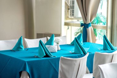 Bir etkinlik için hazırlanmış güzel mavi ve beyaz masa örtüleriyle restoran masaları - seçici odak noktası