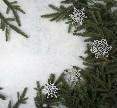 Snowflakes decorations and Christmas tree branches on stone background. Christmas composition. Christmas, winter, new year concept. 