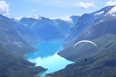 Panorama view over Loen and the inner part of nordfjord and flight of paraglider, Norway. Lovatnet lake from Leon skylift top in Norway. clipart