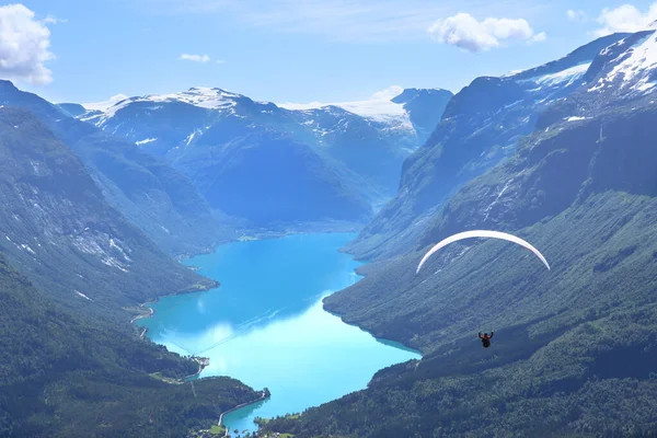 stock image Panorama view over Loen and the inner part of nordfjord and flight of paraglider, Norway. Lovatnet lake from Leon skylift top in Norway.