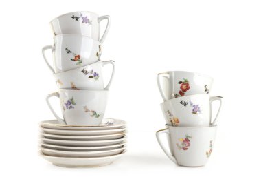 Kahve fincanları ve tabaklar beyaz arka planda izole edilmiş. Bir yığın eski fincan ve çay tabağı..