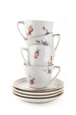 Kahve fincanları ve tabaklar beyaz arka planda izole edilmiş. Bir yığın eski fincan ve çay tabağı..