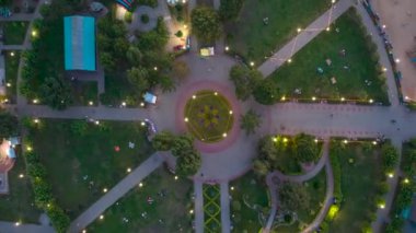 Halka açık bir parkın insansız hava aracının hava görüntüleri. Yeşil çimenler. İnsanlar yol boyunca ilerler. Zaman ayarlı. Üst Manzara. Yüksek kalite 4k görüntü