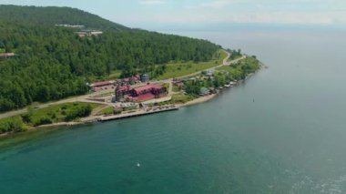 Nehir kıyısı boyunca uçuş. Sahil binaları. Yeşil Orman. Su yüzeyi. İnsan ve doğa. İHA video 4K görüntüsü. Yüksek kalite 4k görüntü
