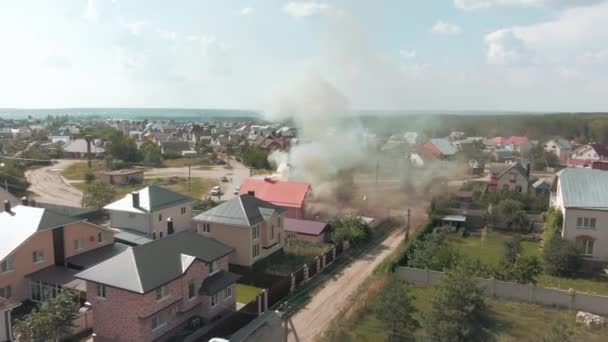 ドローンからの空中ビデオ映像 住宅地への飛行 灰色の煙がコテージから出ています 火事だ 道路だ 高品質4K映像 — ストック動画