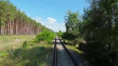  Demiryolu üzerinde uçuş. Doğa ve insan. FPV Drone 'dan ateş ediliyor. Yeşil Orman. Ormandan geçen demiryolu. Yüksek kalite 4k görüntü