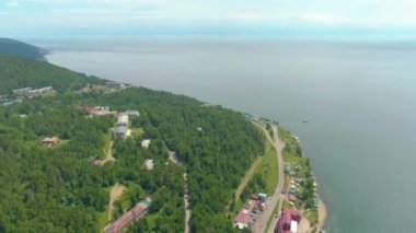 Nehir kıyısı boyunca uçuş. Sahil binaları. Yeşil Orman. Su yüzeyi. İnsan ve doğa. İHA video 4K görüntüsü. Yüksek kalite 4k görüntü