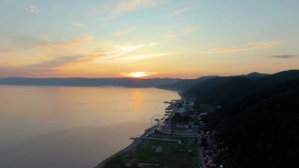 海の上の夕日 海岸線だ シースケープ ドローンからの空中ビデオ映像 水面だ 海岸沿いの建物 高品質4K映像 — ストック動画