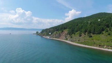 Göl kıyısında uçuş. Yeşil Orman. Kumsal. Sahil şeridi boyunca. Su yüzeyi. İnsansız hava aracı görüntüleri. Yüksek kalite 4k görüntü