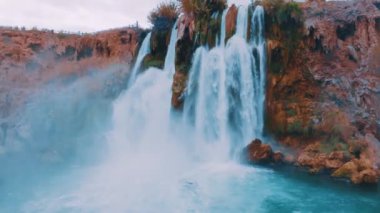 İHA video 4K görüntüsü. Temiz suyu olan mavi bir göl. Güçlü şelale. Vahşi yaşam. Su enerjisi. Yüksek kalite 4k görüntü