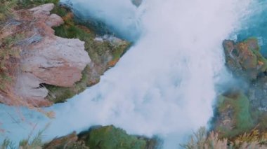 Fırtınalı bir şelalenin kayadaki yavaş çekimi. Akan su. Muhteşem doğal manzara. Hava ağır çekim drone görüntüleri. Yüksek kalite 4k görüntü