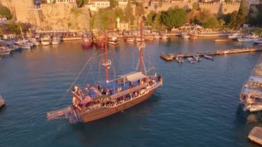 Vintage yelkenli gemi limana giriyor. Turistik bir yer. Liman. Yat limanında tekne ve deniz manzaralı bir deniz manzarası. İHA video görüntüleri. Yüksek kalite 4k görüntü