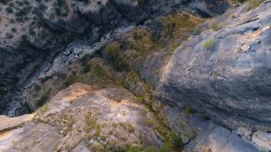 Dağ nehrinin en üst manzarası. Taş geçidi. Kuru nehir yatağı. Buzlu yeşil bitkiler. Hava aracı görüntüsü 4K. Yüksek kalite 4k görüntü
