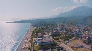 Sahilde Panorama manzaralı uçuş. Deniz manzaralı bir drone görüntüsü. Palmiye ağaçları, kum, plaj şemsiyeleri. Tatilde. Yüksek kalite 4k görüntü