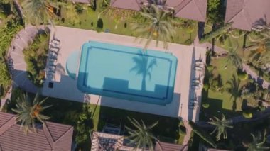 Otel bölgesindeki bir İHA 'dan çekilen hava görüntüsü. Üst Manzara. Yüzme havuzu, palmiye ağaçları, güneşlenme yerleri. Yüksek kalite 4k görüntü