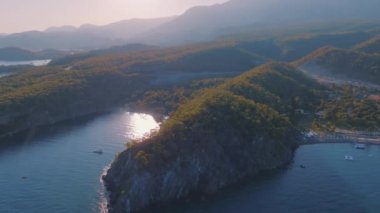 Gün batımında deniz manzarası. Mavi körfezin panorama manzarası bir dağ manzarasının arka planına karşı. İnsansız hava aracı görüntüleri. Yüksek kalite 4k görüntü