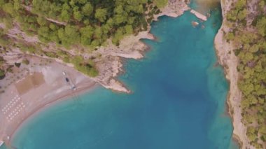 Mavi körfezin insansız hava aracının hava görüntüsü. Deniz Burnu. Temiz, sakin su. Sahilde yeşil ağaçlar. Üst Manzara. Yüksek kalite 4k görüntü