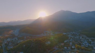 Tatil köyünün insansız hava aracının uçuş ve video görüntüleri. Gün batımı gökyüzü. Arka planda dağlar. Yüksek kalite 4k görüntü