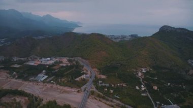 Dağ manzarası. Tatil köyünün insansız hava aracının uçuş ve video görüntüleri. Gün batımı gökyüzü. Büyük yol. Otoyol. Yüksek kalite 4k görüntü