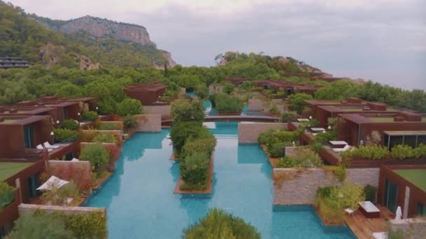从酒店区域无人机拍摄的空中录像 绿树和灌木 酒店房间 游泳池 沙滩遮阳伞和日光浴 高质量的4K镜头 — 图库视频影像