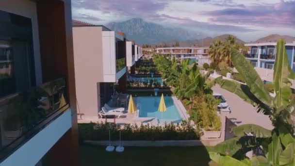 从酒店区域无人机拍摄的空中录像 绿树和灌木 酒店房间 游泳池 沙滩遮阳伞和日光浴 高质量的4K镜头 — 图库视频影像