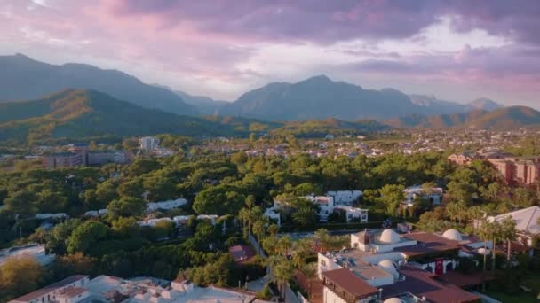 夕阳西下 飞越酒店和高山 美丽的紫色粉色云彩 旅馆的客房 空中无人机画面 高质量的4K镜头 — 图库视频影像