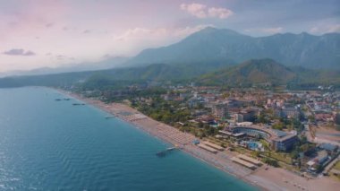 Mavi deniz üzerindeki İHA uçuşunun hava görüntüleri. Arka planda sahil ve dağlar var. Deniz Burnu. Güzel gün batımı. Yüksek kalite 4k görüntü