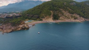 Bir İHA 'nın hava görüntüsü. Mavi körfez ve kayalık sahil. Doğal güzellik. Deniz Burnu. Yeşil ağaçlar kayalarda yetişir. - Evet. Yüksek kalite 4k görüntü