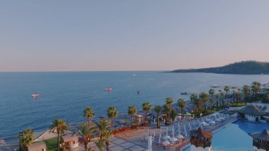 Sahilde Panorama manzaralı uçuş. Deniz manzaralı bir insansız hava aracı. Palmiye ağaçları, kum, plaj şemsiyeleri. Tatilde. Yüksek kalite fotoğraf