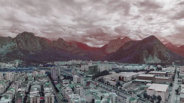 Magic landscape of the city against the backdrop of mountains. Cloudy sky. Flight over rooftops. Aerial drone view. High quality photo