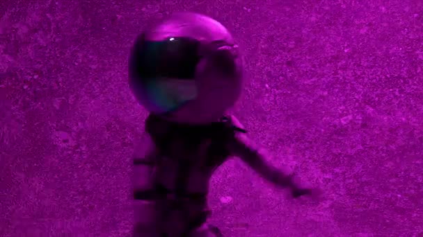 穿着圆圆的大头盔的赛博朋克宇航员在迪斯科舞厅的背景下跳舞 尼昂闪光的光 高质量的4K镜头 — 图库视频影像