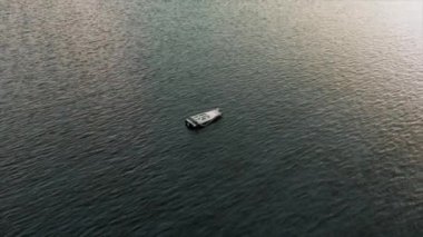 Kozmik okyanusun ortasında modern bir teknenin arkasında dans eden bir astronotun en üst görüntüsü. Uzay elbisesi. 3D animasyon. Yüksek kalite 4k görüntü