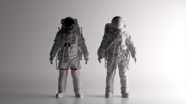 Två Astronauter Vita Rymddräkter Står Vit Bakgrund Belysningen Förändras Svart — Stockvideo
