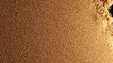 Bronz parçacıklar siyah arkaplanda uçar. Rüzgar renkli kumu uçurur. Barut. Püskürt. Doku. 3d canlandırma