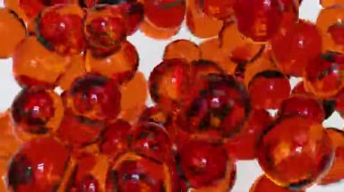 Soyut çok renkli sıvı damlaları. Jel turuncu baloncuklar arka planda kaotik bir şekilde hareket eder ve birbirlerine dokunurlar. 3 Boyutlu Canlandırma.