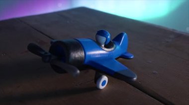 Ahşap bir masada pilotu olan çocuklar için mavi oyuncak bir uçak. Kozmik çevre ve kuzey ışıkları. Havacılık kavramı. 3 Boyutlu Canlandırma.