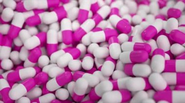 İlaç ve ilaç imalatı, sayısız kapsül. Dönen ilaç tabletlerinin yakın plan görüntüleri. İlaç maddeleri. Eczacılık sektörü. Sağlık hizmetleri kavramı.