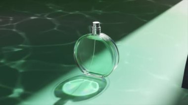Yumuşak ışığı yansıtan koyu yeşil ipeğin arka planına karşı, berrak bir parfüm şişesinin güncel 3D görüntüsü