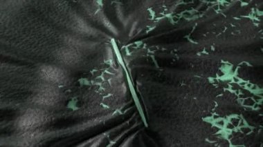 Yeşil çatallı, aşınmış siyah deri ve kıvrımlı yeşil bir çubuk..