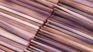 Pembe ve kahverenginin sıcak gölgelerinde düzgünce dizilmiş ahşap çubuklar, pürüzsüz dokular ve doğal ahşap desenler sergiliyor..