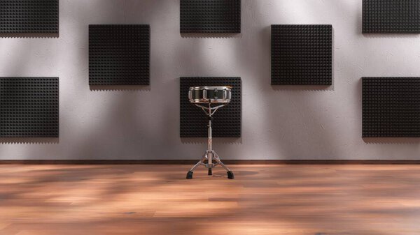 A snare drum placed in the center of a soundproofed music studio with acoustic foam panels on the walls.