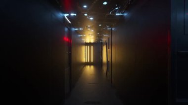Karanlık koridorda bir koridor. Koridorun içinde neon lambalar var. Duvarların ve lambaların koridoru. Karanlıkta neon ışığı.