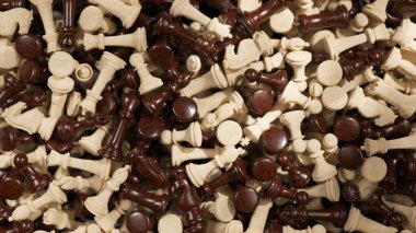 Beyaz ve kahverengi arkaplanda dinamik satranç taşları, stratejik oyun ve entellektüel meydan okumayı temsil eden karmaşık bir yığın oluşturuyor.