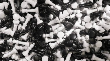 Beyaz ve siyah satranç taşları düşüyor ve siyah bir zemin üzerinde birikiyor, rekabetin, oyun oynamanın ve satrancın karmaşıklığının dinamik ve stratejik bir temsilini oluşturuyor.