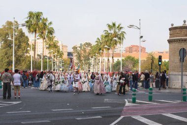 Valencia, Spain - March 17, 2024: People in traditional costumes are going to offer flowers to Our Lady Of The Forsaken In Valencia, Spain clipart